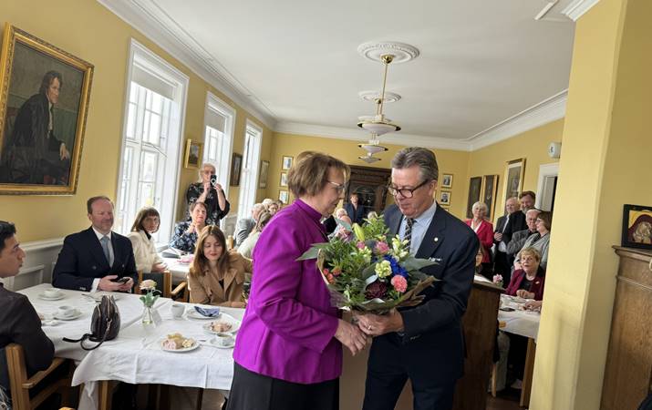 Formaður sóknarnefndar afhendir biskupi blóm