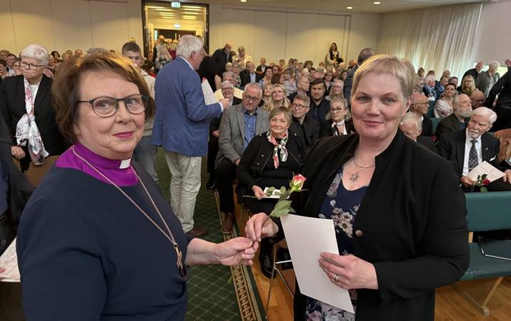 Biskup afhendir Ingunni Aradóttur viðurkenningu fyrir að syngja í kirkjukór í 45 ár