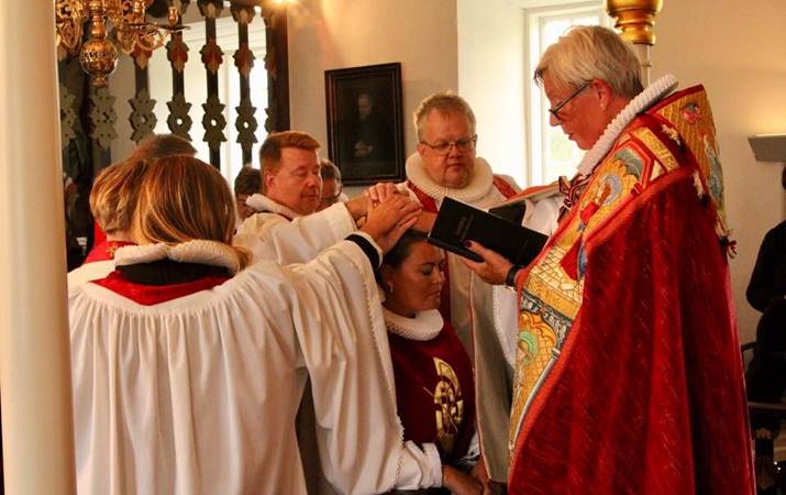 Vígsluþegi krýpur við altari Hóladómkirkju